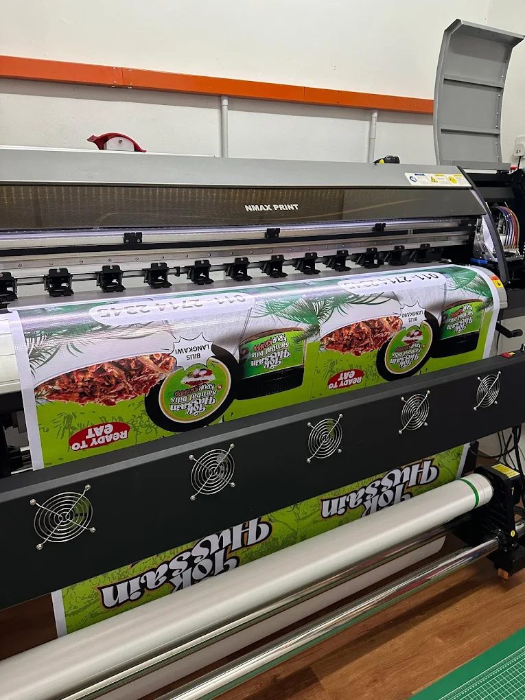 Mesin cetak format besar sedang mencetak banner produk makanan